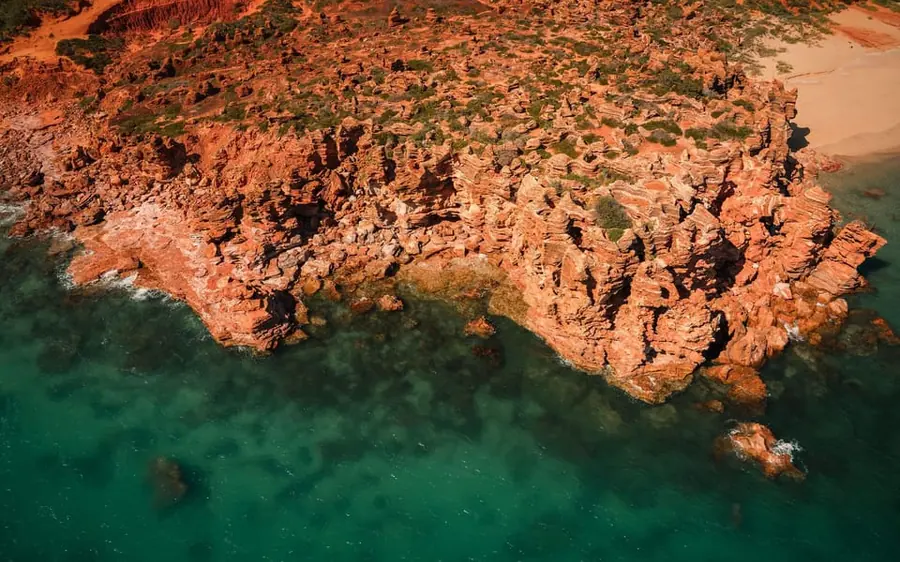 A helicopter flying along the coastline to Eco Beach